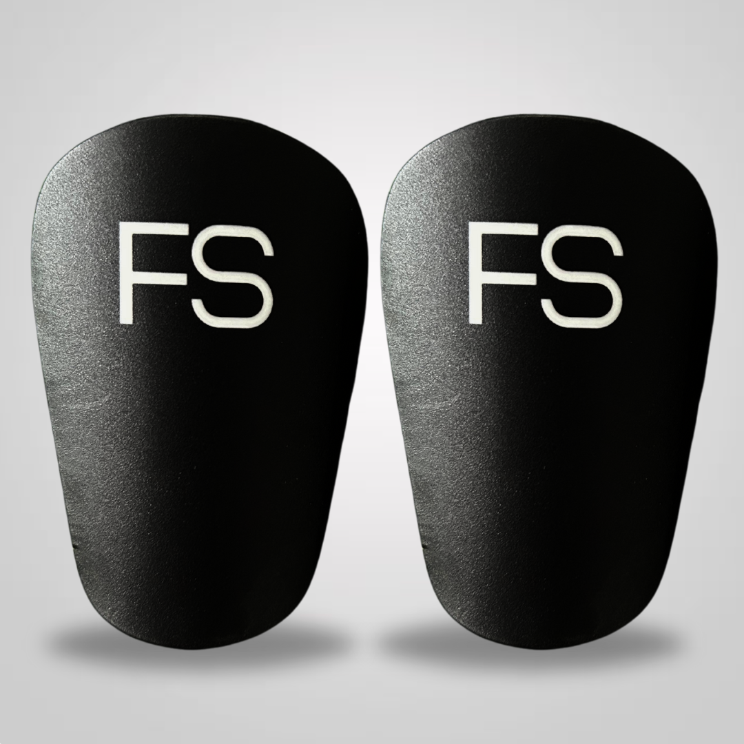 Bild von schwarzen FS Mini Shinpads mit weißem Logo