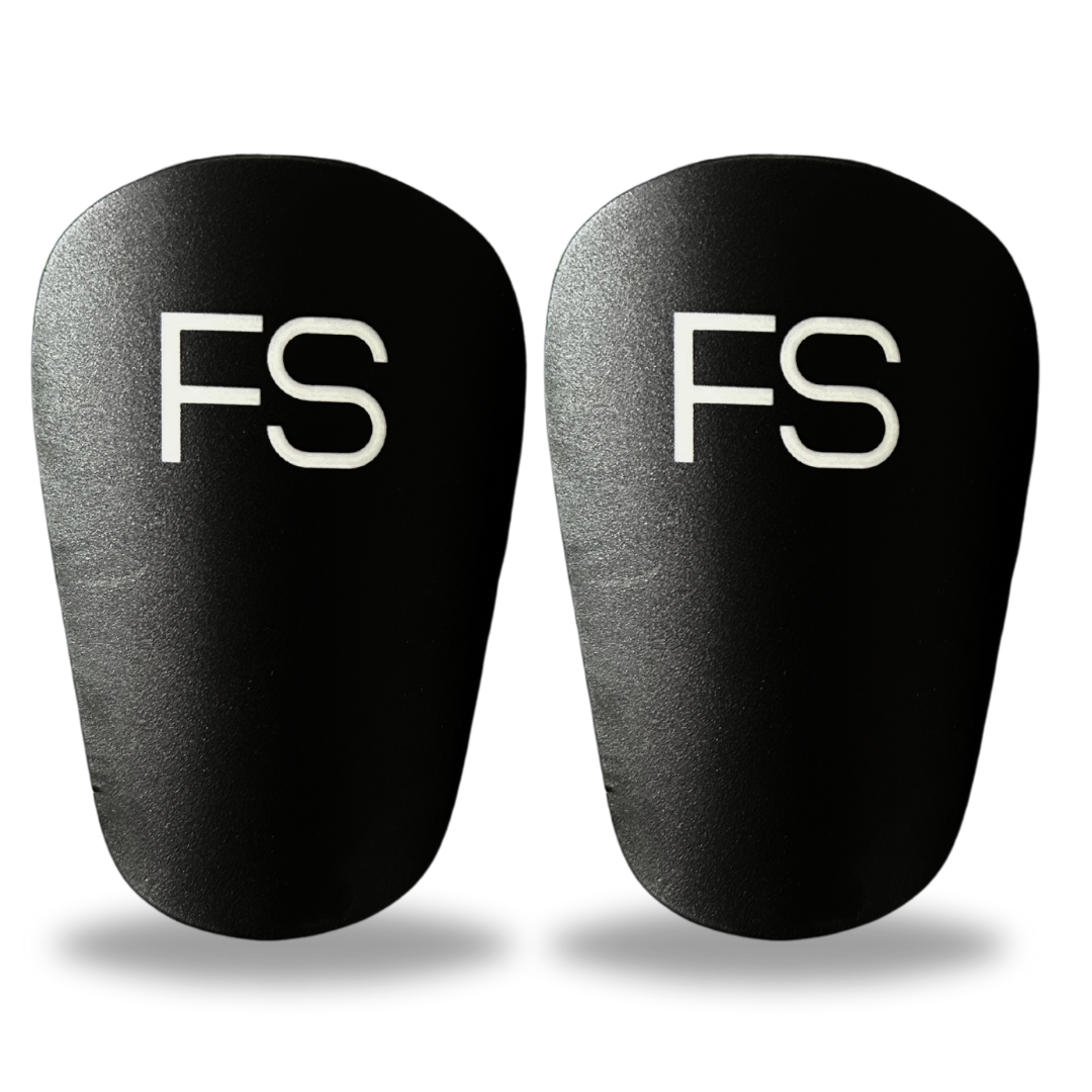 Bild von schwarzen FS Mini Shinpads mit weißem Logo